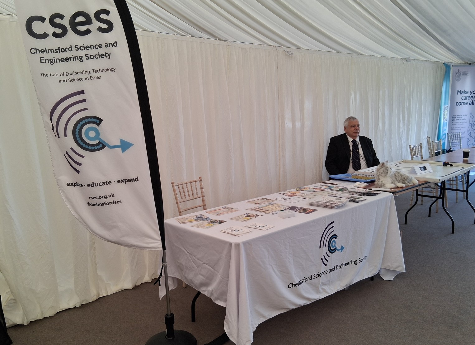 A CSES volunteer sitting at the CSES stand with electronic games