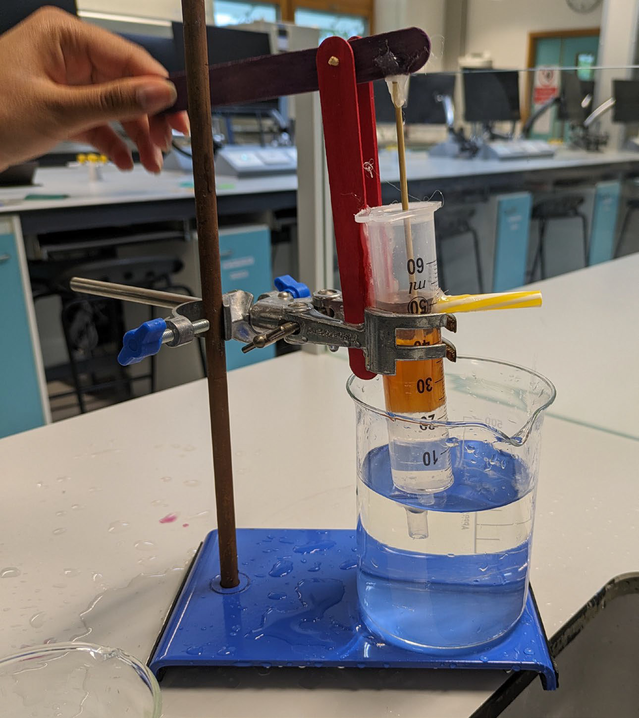 A handmade water pump with a syringe and beaker