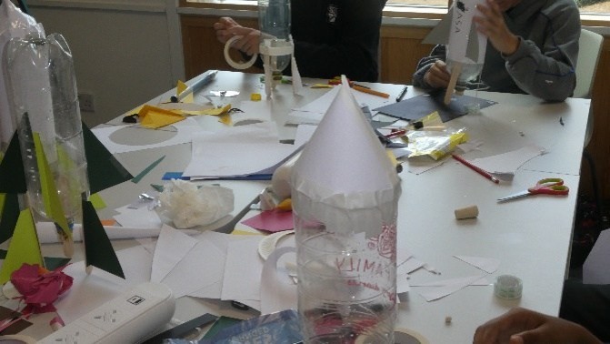 A rocket made of a plastic bottle with a paper nose cone
