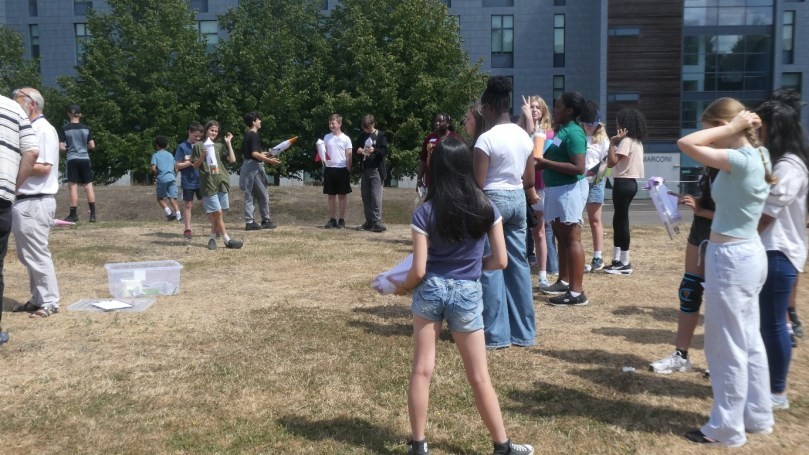 A group of students launching their bottle rockets outside