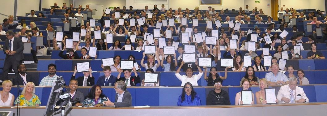 Students at the awards ceremony holding their certificates in the air