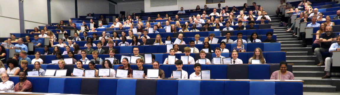 Students at the awards ceremony holding their certificates in the air