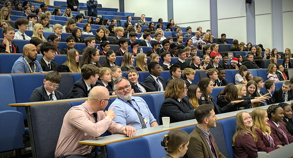 A group of students and teachers in a lecture hall enjoying a talk